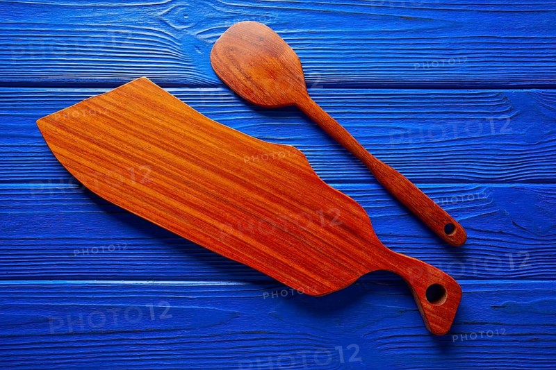 Chef tool spatula and table board on a blue wooden background