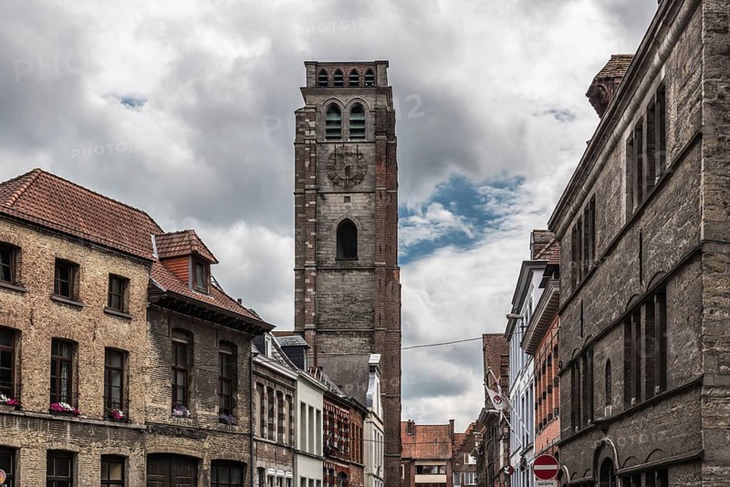 Tournai Doornik, Walloon Region Belgium, 08 14 2019: Facades of residential and commercial buildings in old town with the tower of the Saint Brice church