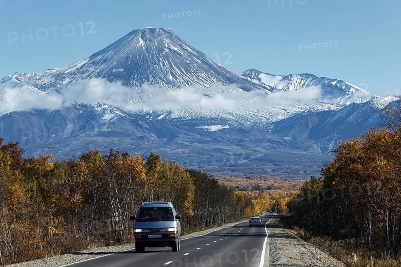KAMCHATKA, RUSSIA, SEP 30, 2012: Autumn view of cars on driving road to active Avachinsky Volcano on Kamchatka Peninsula on sunny, cloudless day with blue skies. Russian Federation, Far East