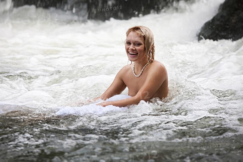 Young naked woman swimming in a river