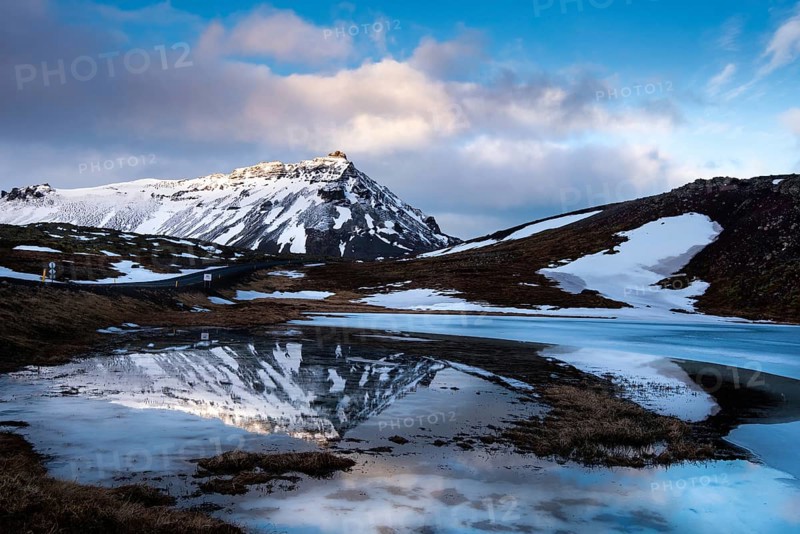 Icelandic landscape with frozen lake and stapafell mountains covered in snow and reflected on water at snaefellsnes peninsula in Iceland