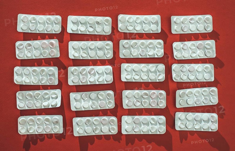 Packs of pills on red background