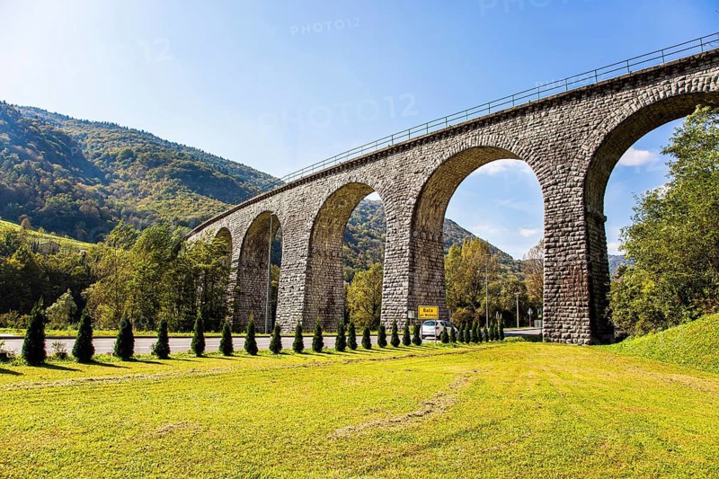 Picturesque Julian Alps. Beautiful sunny autumn day. Majestic powerful bridge over the river Idrija. The beauty of the Julian Alps. Travel to Slovenia