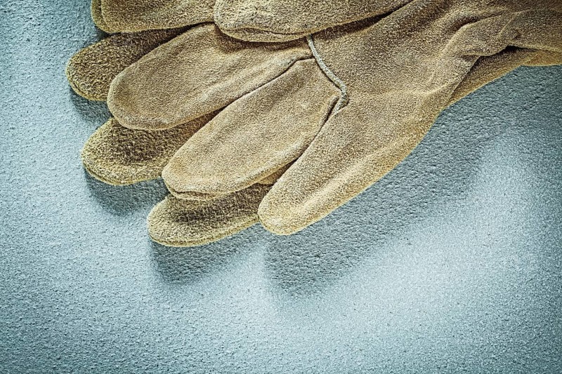 Protective gloves on concrete surface construction concept