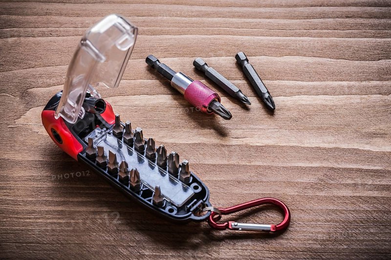 Toolbox with interchangeable stainless screwdriver heads on wooden board