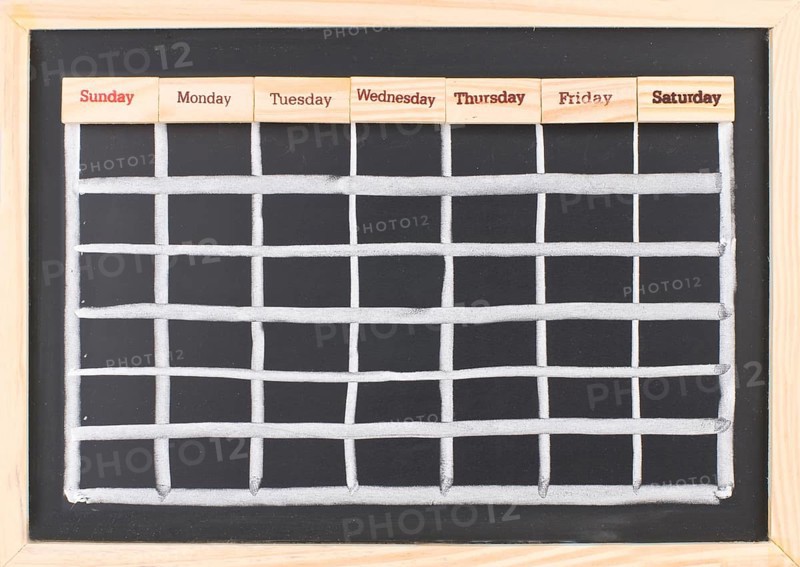 Monthly calendar with week words print on wood on blackboard