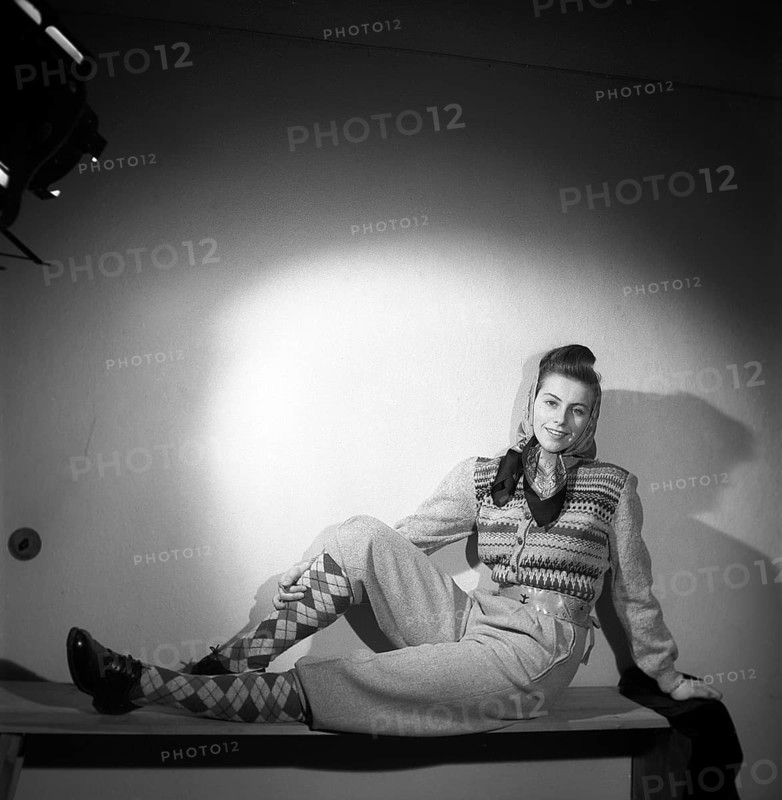 Fashion of 1946. A woman pictured wearing the typical fashion of the postwar era. She is dressed in this year's fashion and clothing for outdoor, sports and leisure use. The trousers are made of strong and durable fabric and she is wearing a warm knitted long-sleeved jumper. She has a scarf around her head. Kristoffersson ref Y68-4