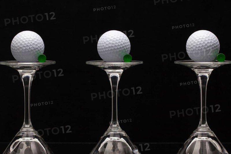Three glasses of champagne with golf balls