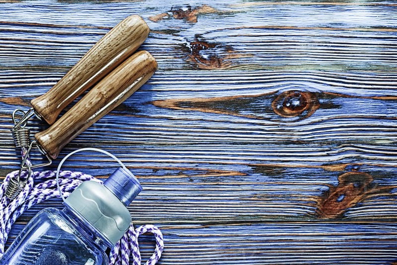 Jumping rope water shaker on blue vintage wooden board