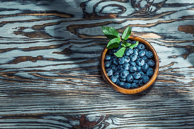 Ripe huckleberries in wooden bowl