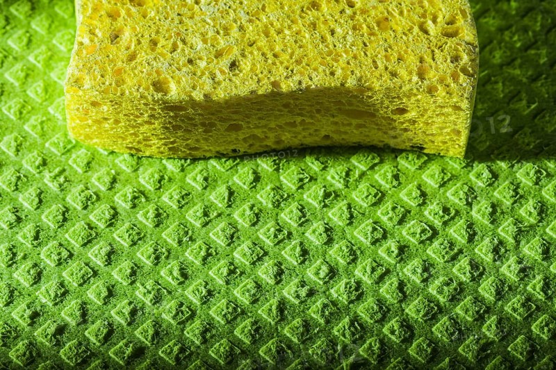 New yellow sponge on green dishcloth
