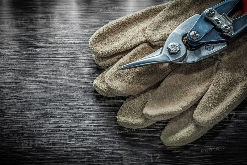 Safety gloves steel scissors on wooden board