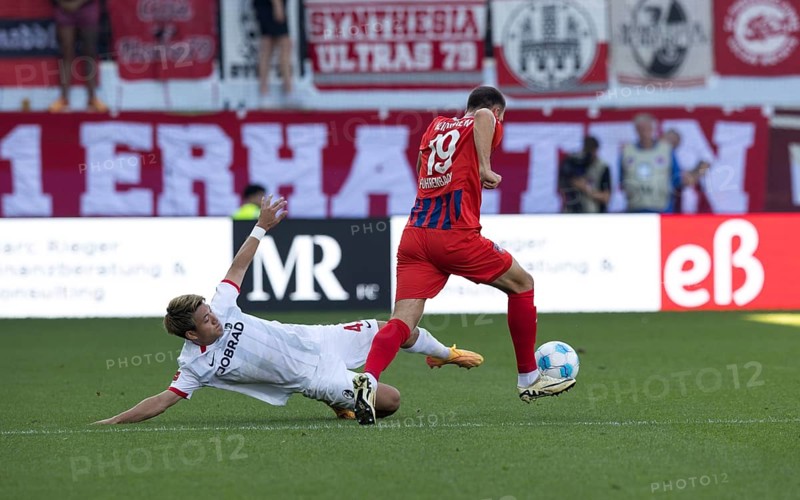 Football match, Ritsu DOAN SC Freiburg left, lying down, tries to separate Jonas FÖHRENBACH 1.FC Heidenheim from the ball, Voith-Arena football stadium, Heidenheim
