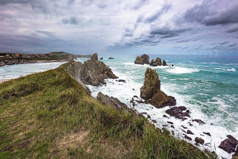 Dramatic stormy sky. Windy stormy day on the Atlantic coast. Surf waves with a foam crest. Cantabria Beaches, Portio Beach. Noon on the beach of Playa di Arnia, Spain, Europe