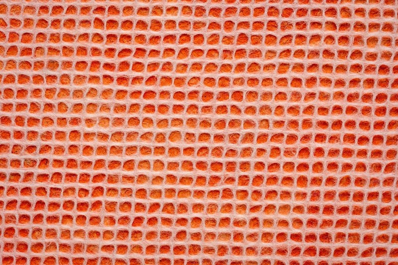 White Thai mulberry lace paper with a grid pattern against orange background
