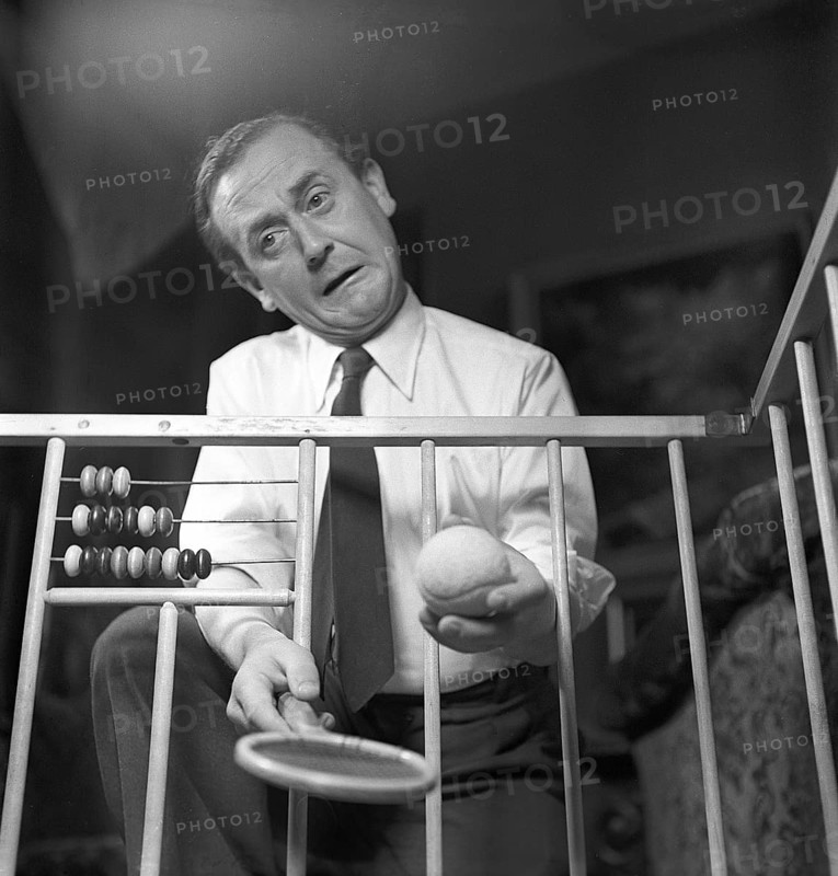 Father in the 1940s. Actor Åke Söderblom, 1910-1965 tries his best at amusing his son from outside the playpen. Sweden 1949 AN92-4
