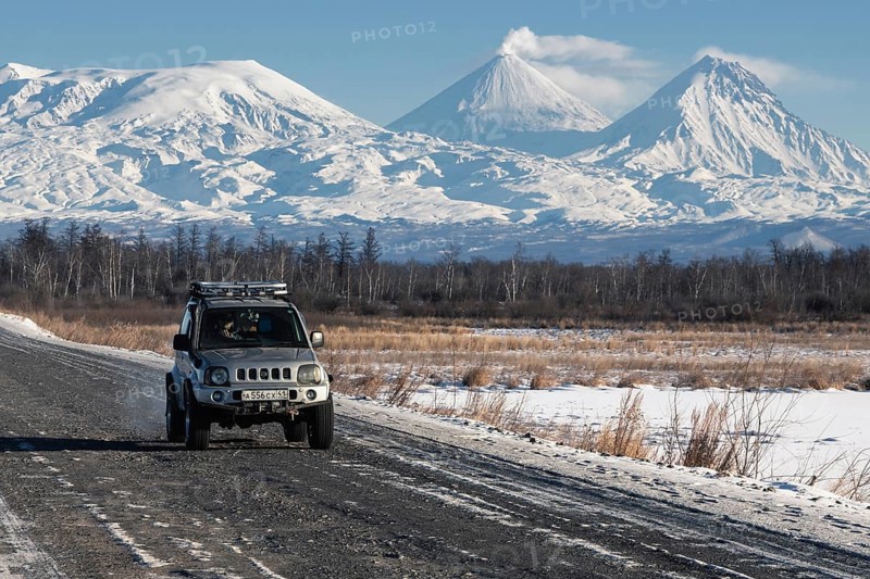 Japanese Sport Utility Vehicle Suzuki Jimny driving along road on background beautiful winter landscape travel destinations, active Kluchevskoy Volcano. Kamchatka Peninsula, Russia, January 7, 2016, Europe