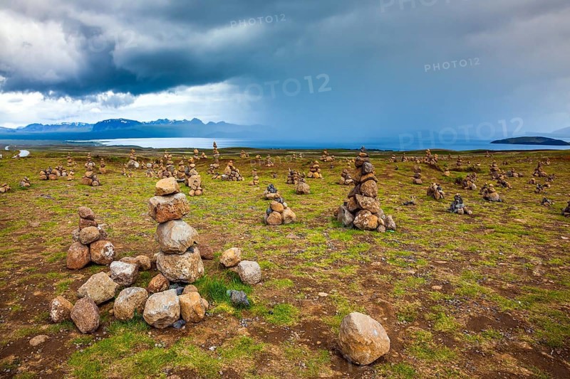 Stone pyramids bring good luck in the journey. The stone pyramids are a symbol of Iceland. Field of stone pyramids. Cloudy summer cold day. The concept of active, ecological and exotic travel