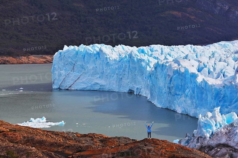 The woman - tourist admire the white-blue icy splendor. Giant lake Perito Moreno glacier