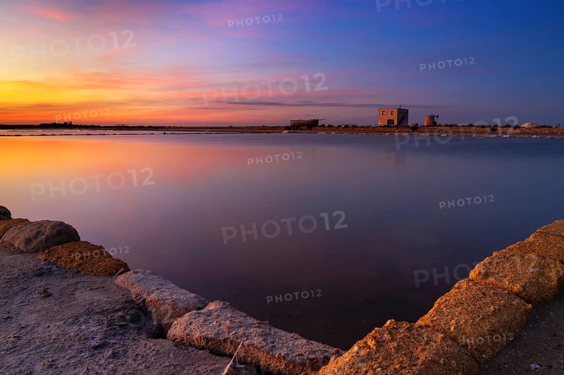 Landscape view of calm sea salt basins and flats near Trapani and Paceco at sunset