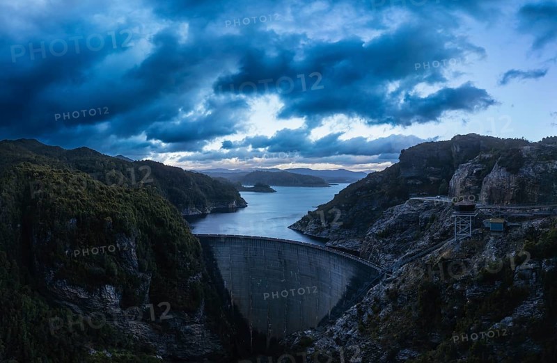 An aerial view of the Gordon Dam on a cool summer's day. It is a unique double curvature concrete arch dam with a spillway across the Gordon River near Strathgordon, South West Tasmania, Australia, Oceania