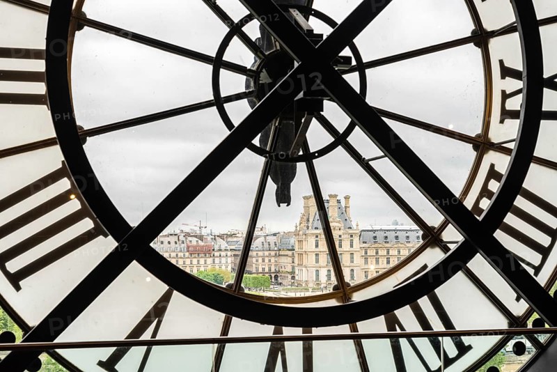View of the Louvre through a large Clock from Museum d'Orsay in Paris, France, Europe