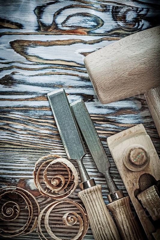 Wooden hammer chisels planer curled shavings on wood board