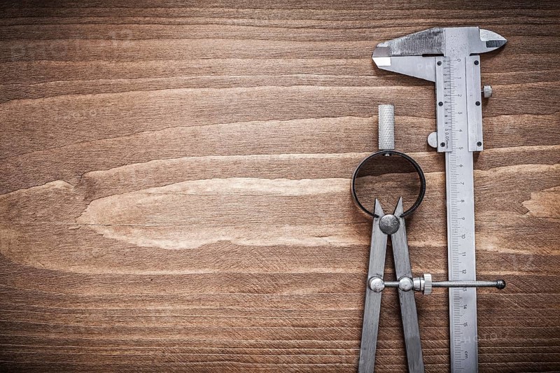 Slide caliper divider on wooden board copyspace construction concept