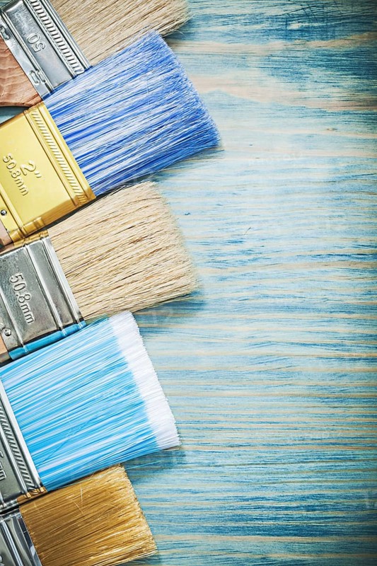 Set of paint brushes on wood board construction concept