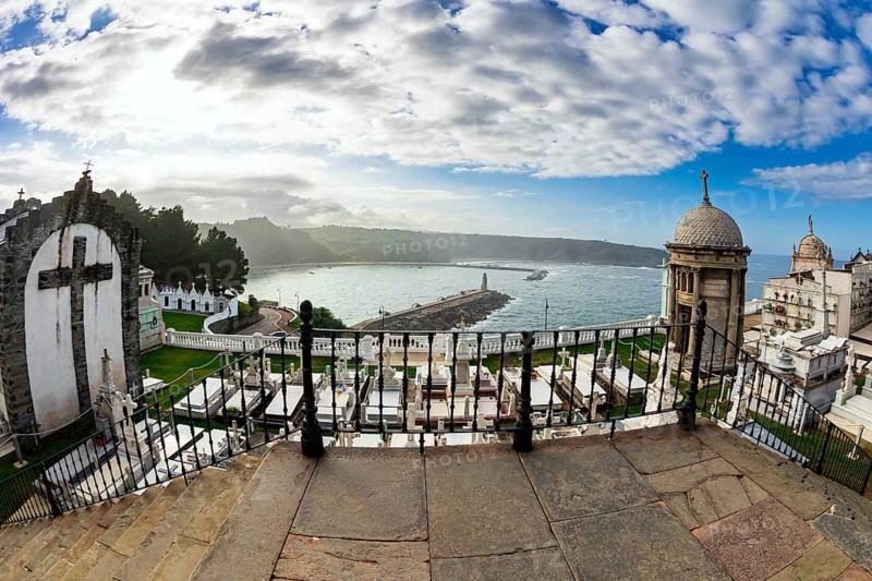Ancient cemetery over a cliff to the Atlantic Ocean. Luarca is the most beautiful small town in Asturias. Picturesque fishing port in the bay. Romantic trip to Spain