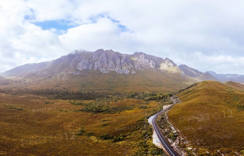 An aerial view of Gordon River Rd at the Sentinel range of mountains near Bitumen Bones Sculpture on a hot summer's afternoon in Southwest National Park, Tasmania, Australia, Oceania
