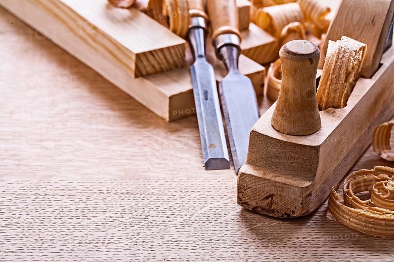 Veri close up view old fashioned plane chisels planks shavings on wooden board