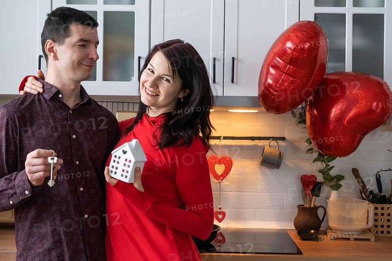 Man and woman in love date at home in kitchen with keys of house. Valentine's Day, happy couple, love story. Love nest, mortgage, relocation, purchase, real estate, housing for young family