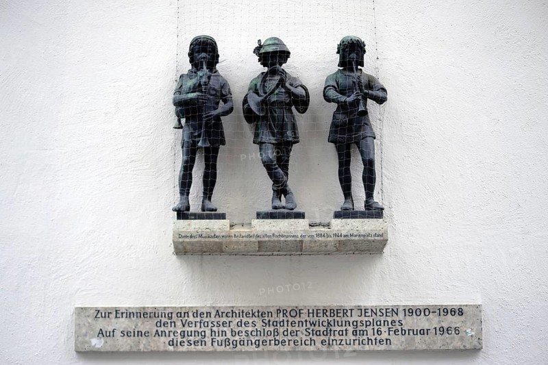 Munich, Germany - June 30, 2018: Three musicians sculptures and part of the old fish fountain above a memorial plaque in honour of Professor Herbert Jensen on 30 June 2018 in Munich