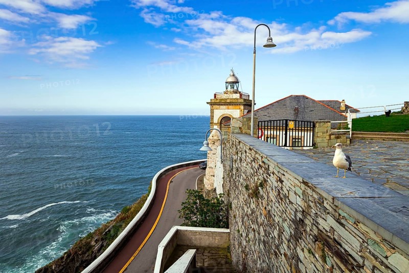The majestic Atlantic Ocean. Asturias. Romantic trip to Spain. Beautiful road to lighthouse and Chapel de la Atalaya. Unusual impressive architecture of the Luarca