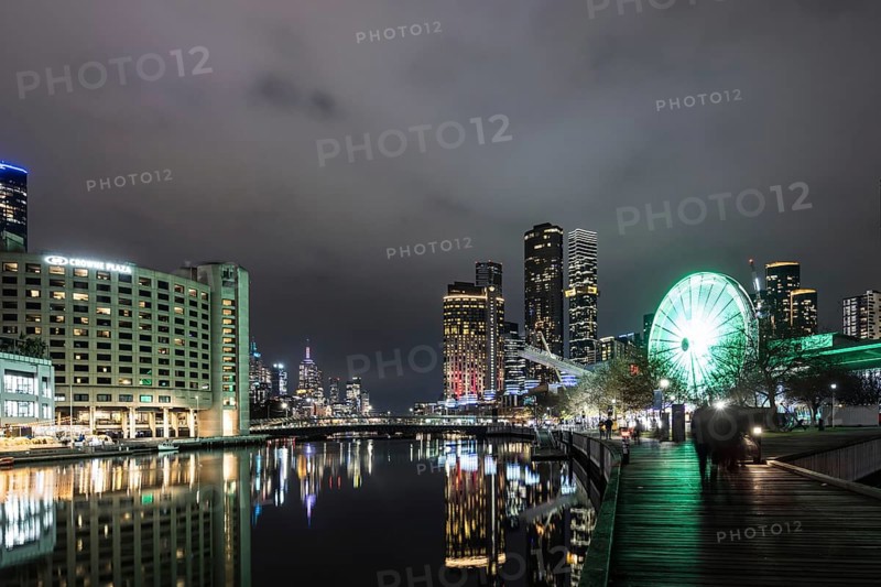 MELBOURNE, AUSTRALIA - JULY 5, 2024: Polly Woodside Park and ferris wheel and Melbourne skyline as seen at dusk from Melbourne Exhibition Centre in Melbourne, Victoria, Australia, Oceania