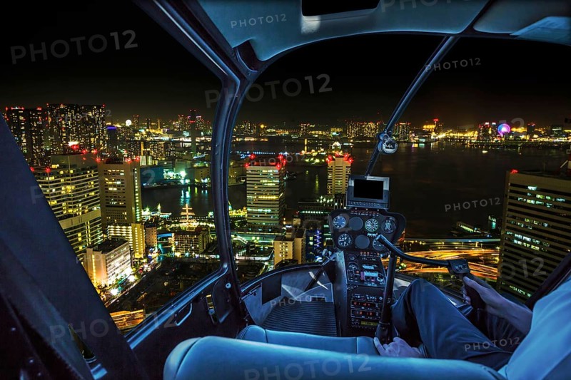 Helicopter flying over Tokyo cityscape, the Bay area with its bridges and Odaiba by night from Tokyo skyline in Japan