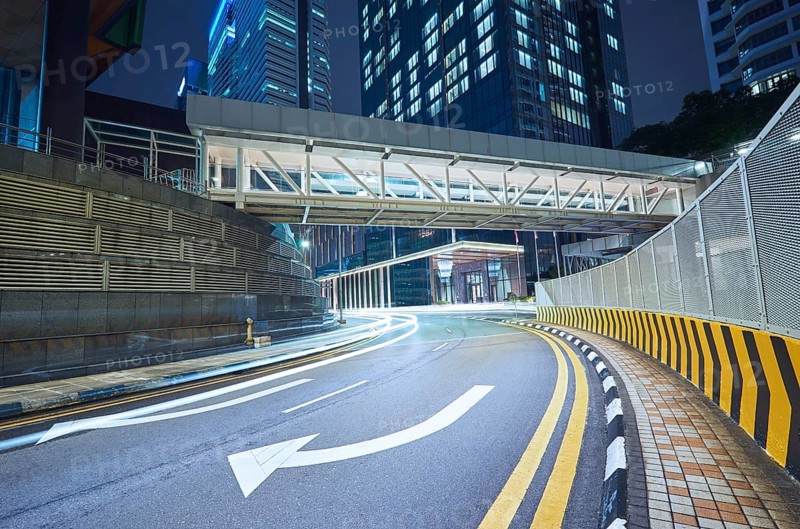 Empty asphalt city street road with walkway bridge and light trail, night scene