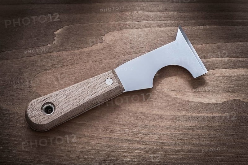 Metal putty knife on vintage wood board horizontal image