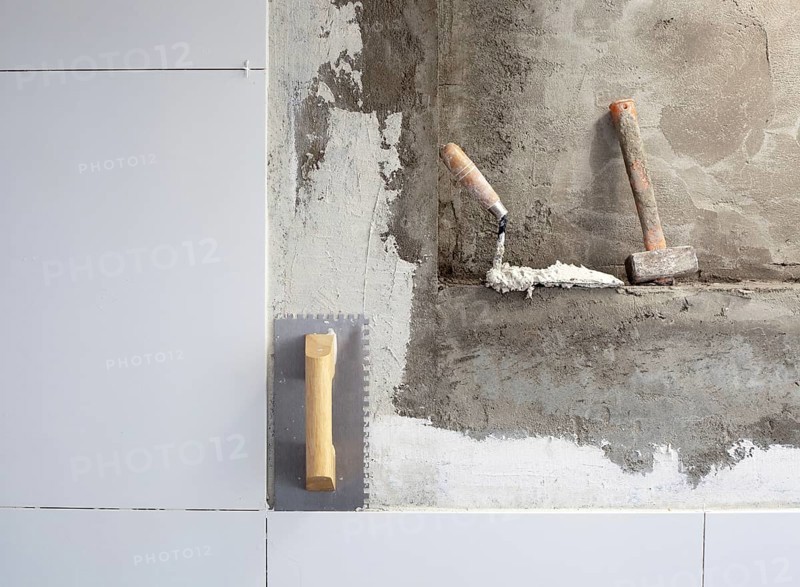 Construction tools notched trowel on tiles mortar wall