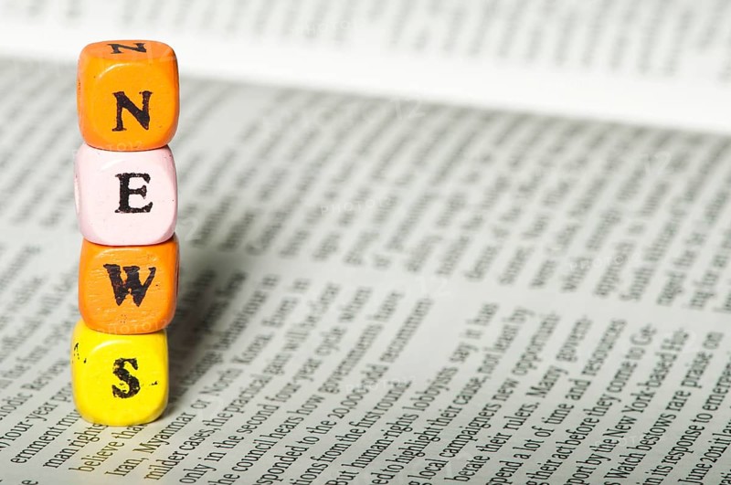 Word news.Wooden cubes on newspaper. Close up studio shot