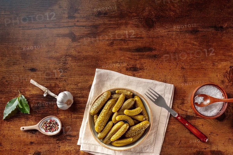 Pickled cucumbers with salt, pepper, garlic, and bay leaf. Fermented food. Homemade canned gherkins. Overhead flat lay shot with copy space, Food photography