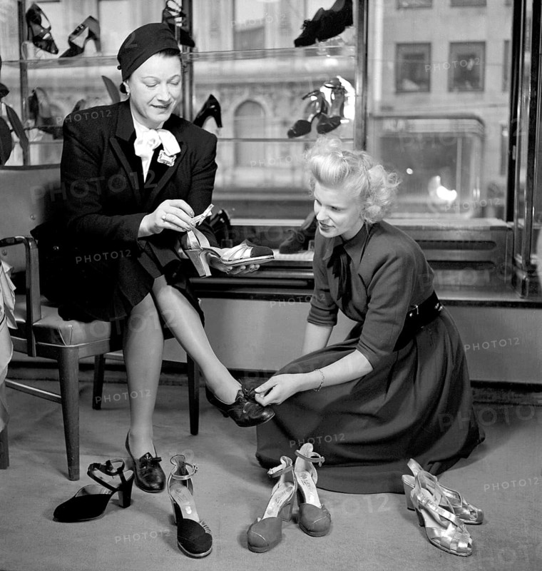 Shoe store in the 1940s. A woman in the shoestore on Hamngatan Stockholm 1948. She seems to look for something special in the new shoes she is looking for, and have several different pairs of shoes to try on. Sweden 1948. Conard ref 950