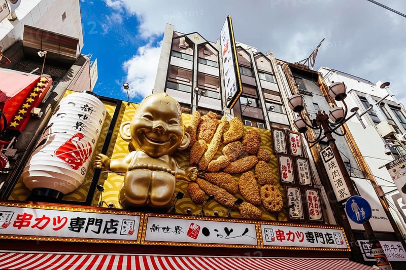 OSAKA, JAPAN - SEPTEMBER 24 2024: Osaka's famous Dotonbori area with many restaurants and iconic food signage, including this golden baby in Osaka, Japan, Asia
