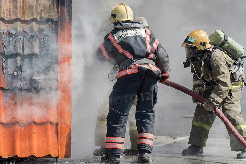 Firefighters extinguishing fire from fire hose, using firefighting water-foam barrel with air-mechanical foam during professional holiday Firefighters Day. Kamchatka Peninsula, Russia, April 27, 2019, Europe