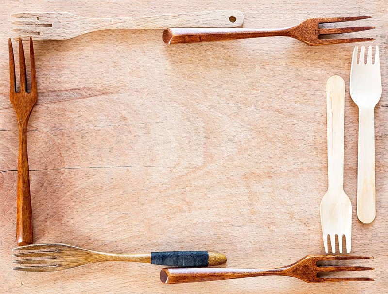 Wooden kitchenware frame on a wooden background from above. Studio shot. Kitchen utensil