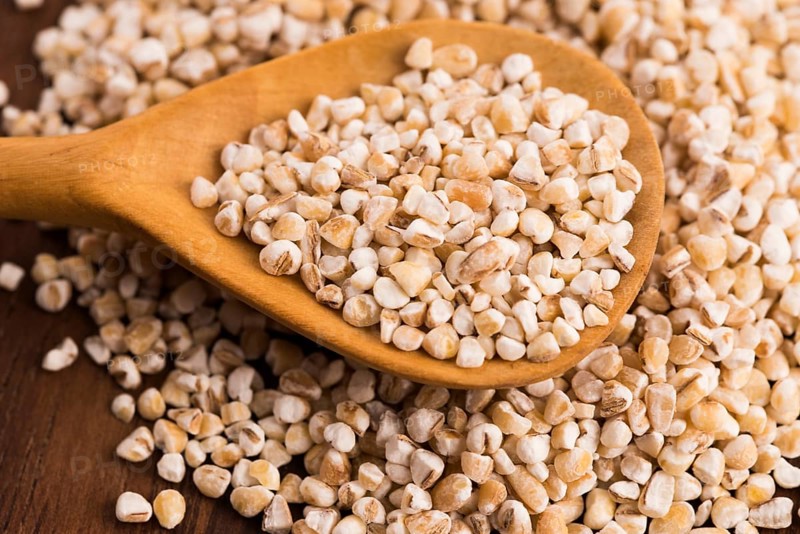 Barley groats on wooden spoon