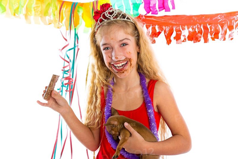 Happy party girl with puppy present eating chocolate in birthday dirty mouth