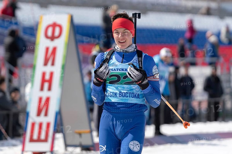 Portrait of sportsman biathlete Sporshev Nikita at finish line after skiing and rifle shooting. Junior biathlon competitions East of Cup. Petropavlovsk, Kamchatka Peninsula, Russia, April 14, 2019, Europe