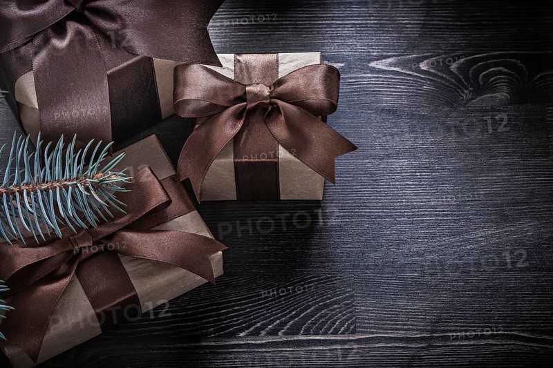 Fir branch Christmas gift boxes on wooden board holiday concept